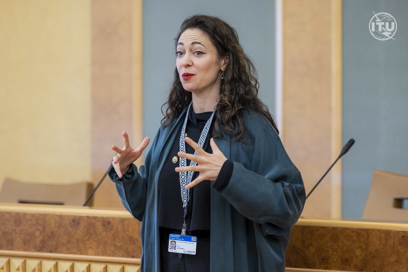 Lucy Antrobus speaking and gesturing at the ITU Global Symposium for Regulators