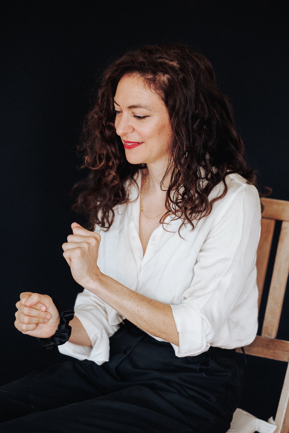 Lucy Antrobus seated, mid-gesture, explaining an idea