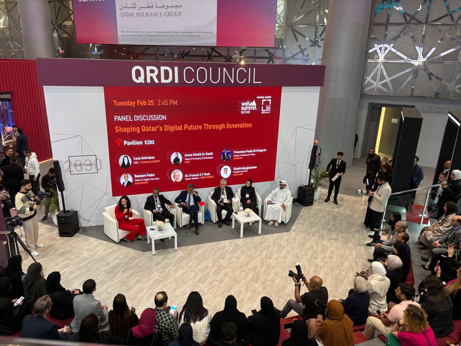 Lucy Antrobus on stage with fellow panellists in front of a large audience at the QRDI Council pavilion