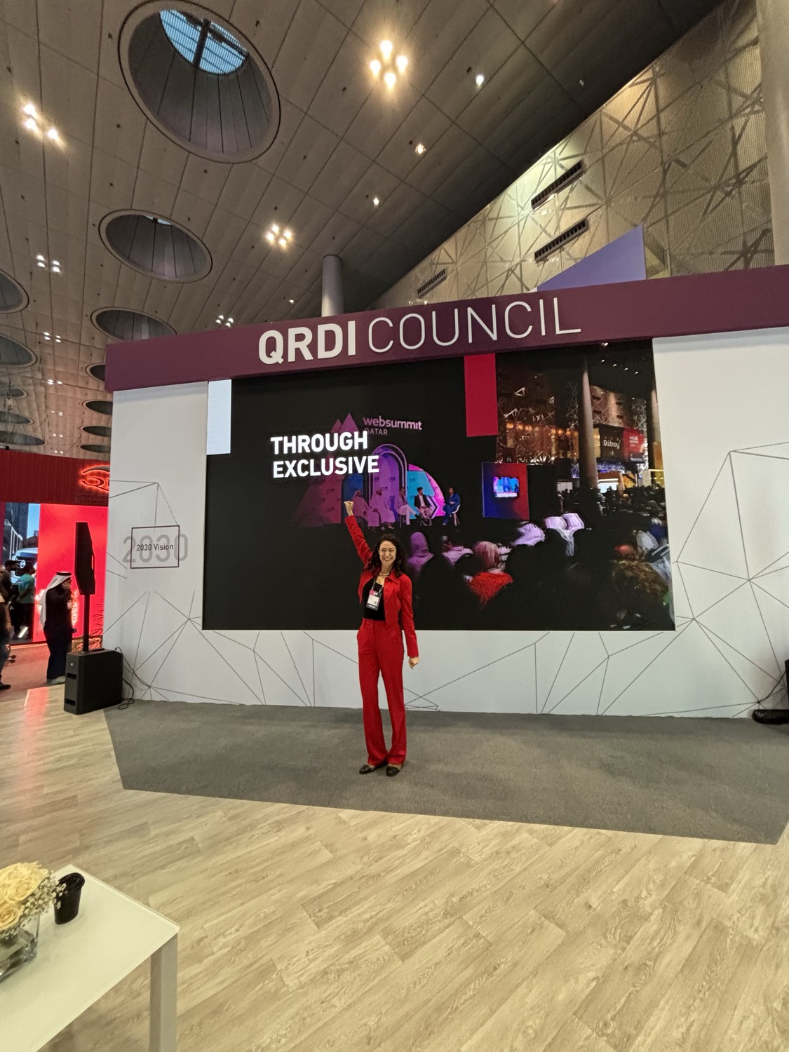 Lucy Antrobus in a red suit on stage at the QRDI Council pavilion, Web Summit Qatar